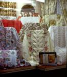 Store window display showing various bolts of fabrics on Queen Street West 1976-1978.