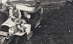 [Three men posing on a car] November 21, 1934.
