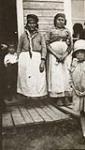 Cree women and children standing on porch [graphic material] ca. 1931.
