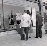 Celia Franca looking at store window display for the National Ballet of Canada ca. 1952-1955.