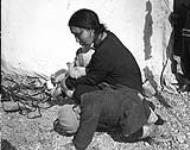 Inuit woman with her baby and another child, in Chesterfield Inlet (Igluligaarjuk), Nunavut 1948.