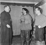 [Father Treboal and Paradis in R. C. Mission house with an unidentified Innu man] Original title: Father Treboal and Paradis in R.C.Mission house with aged Eskimo 1953