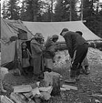 Corporal Jim Davies, of the R.C.M.P. visiting Inuit women and children living on the Strutton Islands January, 1946.