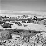 R.C.M.P. Corporal Jim Davies taking a short break to prepare food during his trip from Moose Factory Island, Ontario, to Great Whale [Kuujjuarapik], Quebec January, 1946.