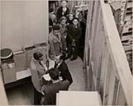 « Tit-Coq » - Gratien Gélinas au micro de CKAC avec d'autres personnes. [document iconographique] [1948-1953].