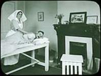 Massage - Physio with man on a table in smaller room - Military Hospital Commission ca. 1918-1925.