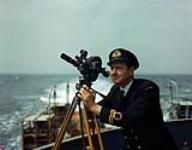 RCNVR Lieutenant using a Bell and Howell movie camera [ca. 1942-1945]