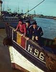 RCN Motor Torpedo Boat sailors Irving Brown and Harvey Blandford visiting an old Belgian fishing schooner, Ostend, Belgium, with an MTB in the background [ca. 1942-1945]