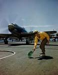 Deck Landing Control Officer (DLCO) signalling Hawker Sea Fury to take off, on an RCN aircraft carrier [ca. 1947-1956]