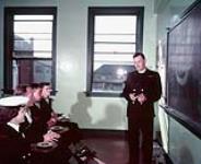 Naval Chaplain discussing group [ca. 1942-1965]