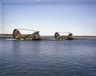 Two CH-113A Voyageurs Hover Over Water Side View ca. 1943-1965.