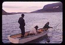 Three men in a wooden boat laying char nets, Killiniq, Nunavut [between July 24-August 9, 1960]