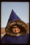 Boy wearing a dark blue canvas parka, Cape Dorset, Nunavut [between August 24-October 3, 1960]