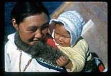 Kananginak's wife carrying her infant, Cape Dorset, Nunavut [between August 24-October 3, 1960]