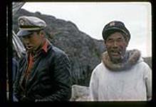 Henry Anatuk with another man standing outside, Killiniq, Nunavut [between July 24-August 9, 1960]