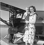[Mrs. Jean Nyhus holding her son Dwayne Nyhus while her husband Dr. Tron Nyhus boards a plane, Fort Simpson, Northwest Territories] 1956