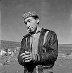 [Imaapik Jacob Partridge smoking outdoors, Iqaluit, Nunavut] [between 1956-1960]