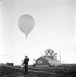 [Man holding a weather balloon] [between 1956-1960]