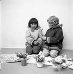 [Two Brownies, Martha (left) and Jo (right), pressing wildflowers, Iqaluit, Nunavut] 1960