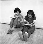 [Two girls reading books, Iqaluit, Nunavut] 1960