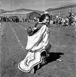 [Mrs. Ken Green carrying a child on her back, Niaqunngut, Iqaluit, Nunavut] 1960