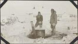 Bob [Robert Thorbjörn Porsild] and Constable Millan cooking dog feed at the R.C.M.P. barracks at Arctic Red River 1928.