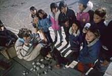 Un groupe d'enfants [dernier rang Judy Sulurayok, Della Napayok, Lucy Kadludjak, Rosie Sulurayok, Selma Karetuk, Mary Kablutsiak, première rangée à gauche Donna Adams] avec Mme A. V. Gundy, à Arviat 1979.
