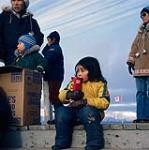 Young girl holding can of chips, Pond Inlet 1979.