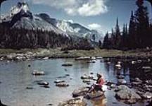 Woman sitting on rock on Lake O'Hara, Yoho National Park, British Columbia September 1945