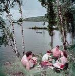 Deux hommes et deux femmes piqueniquent au lac Massiwippi, au Québec juillet 1950