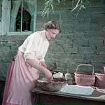 Woman dressed as a nineteenth century dairy farmer makes butter pats as represented in the NFB production on the Canadian dairy industry August 1950
