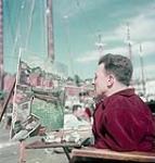 Disabled male artist paints with brush in mouth 1952