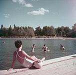 Woman reclined on dock at Clear Lake, Riding Mountain National Park, Manitoba 1952