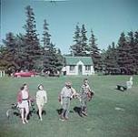 Two men and two women golfing, Prince Edward Island National Park [Deux hommes et deux femmes jouant au golf, au parc national de l'Île-du-Prince-Édouard.] juillet 1953