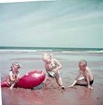 Children playing at Brackley Beach, Prince Edward Island National Park, P.E.I. [Les enfants jouant à Brackley Beach, parc national de l'île du Prince Edouard.] juillet 1953