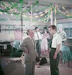 Mr Edwards, left foreground, angrily announces that because of damage and dirt caused by the Teenage Club to the Community Centre, they will be barred from using it. A scene from "Having Your Say" in the "What Do You Think?" series.  1954