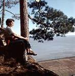 Profil d'une femme assise sur une roche au bord d'une falaise. Chalet Shilly Shally, parc de la Gatineau n.d.