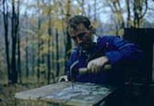 Mike Eaton building a new bird table. Shilly Shally Lodge, Gatineau Park March, 1963