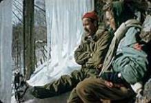 Man and woman resting in an ice cave. Shilly Shally Lodge, Gatineau Park April, 1960