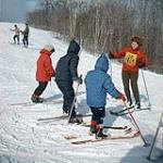Female ski instructor teaching a class on the hill. Midget Skiing (probably Camp Fortune) n.d.