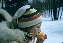 Gros plan de profil d'Anne Rowley mangeant une orange. Club Alpine, parc de la Gatineau n.d.