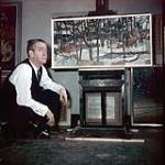 Alan Jarvis crouching in front of a painting by Gordon Smith, at the National Gallery of Canada [between 1955-1963]