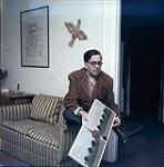 Guy Roberge holding a painting by Jean-Paul Lemieux [entre 1955-1963]