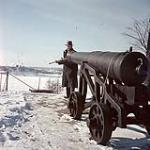 Man loading a cannon on a bank of the Ottawa River near Parliament Hill, Ottawa [entre 1955-1963]