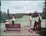 Teeing off on the golf course at Riding Mountain National Park, Manitoba. juillet 1950.