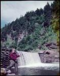 Leo J. Lyons of Quincy, Massachusetts, fishing at Point Wolf River, Fundy National Park, New Brunswick. [Leo J. Lyons de Quincy Massachusetts, faisant de la pêche à la rivière pointe Wolfe, parc national de Fundy, Nouveau-Brunswick.] juillet 1950.