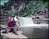 Leo J. Lyons and sons Joseph and Richard of Quincy, Massachusetts, fishing at Point Wolf River, Fundy National Park. [Leo J. Lyons et fils Joseph et Richard de Quincy, Massachusetts, faisant de la pêche à la rivière pointe Wolfe, au parc national de Fundy, Nouveau-Brunswick.] juillet 1950.