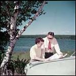 Tourists check vacation route by the shore of Six Mile Lake, near Haney Harbour, Georgian Bay, Ont. juillet 1951.