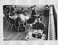 Salle de classe où des élèves utilisent des appareils audio [ca 1955-1976].
