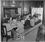 Farm Service Force : le repas du soir au camp du YMCA. La directrice du camp madame Evelyn Brown se trouve au bout de la table 1942